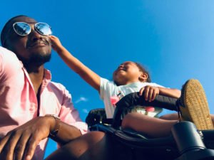 baby reaches at happy father's sunglasses