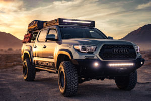 a sporty Toyota Tacoma truck driving into the mountains